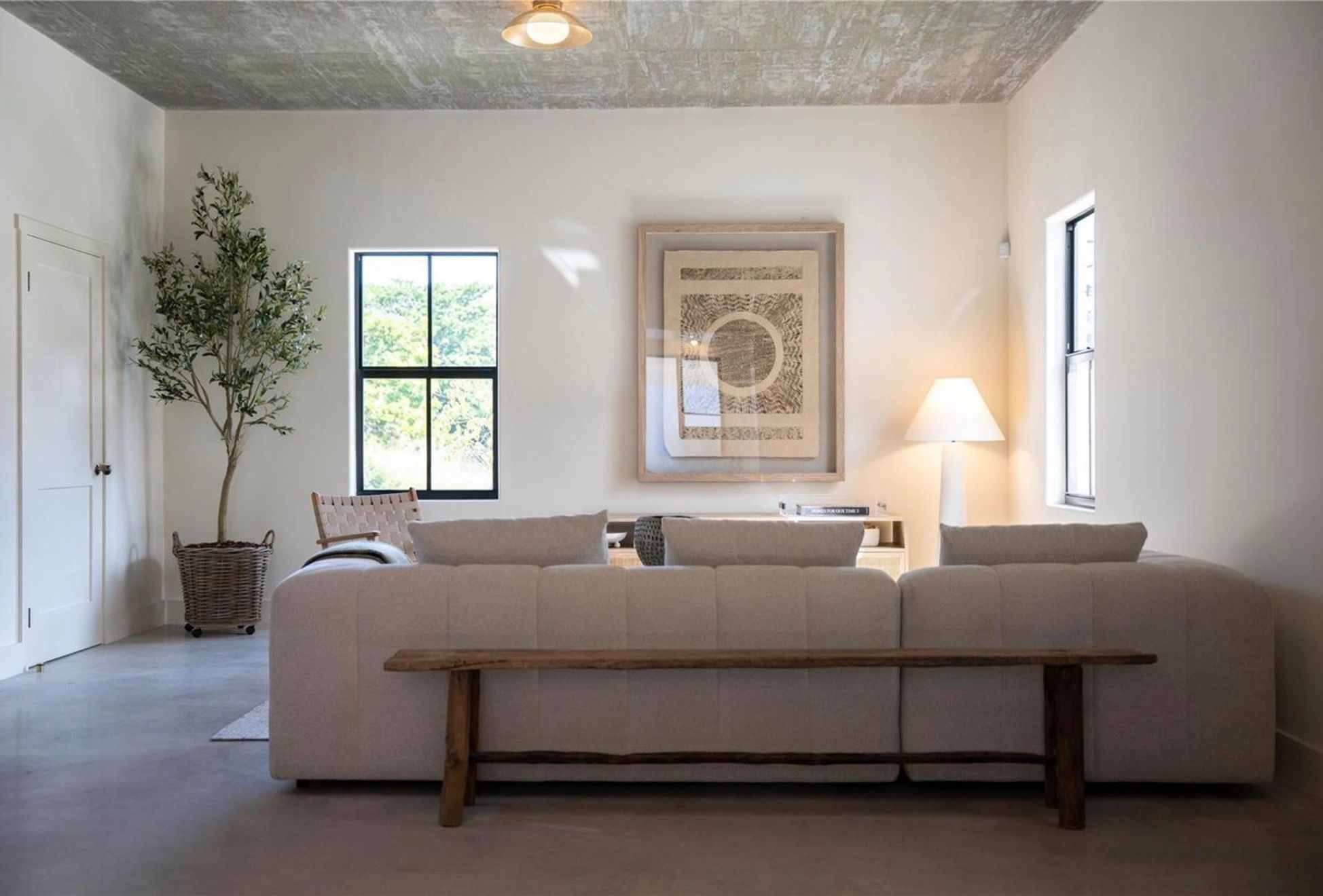 Living room with board-formed concrete ceiling and linen sofa
