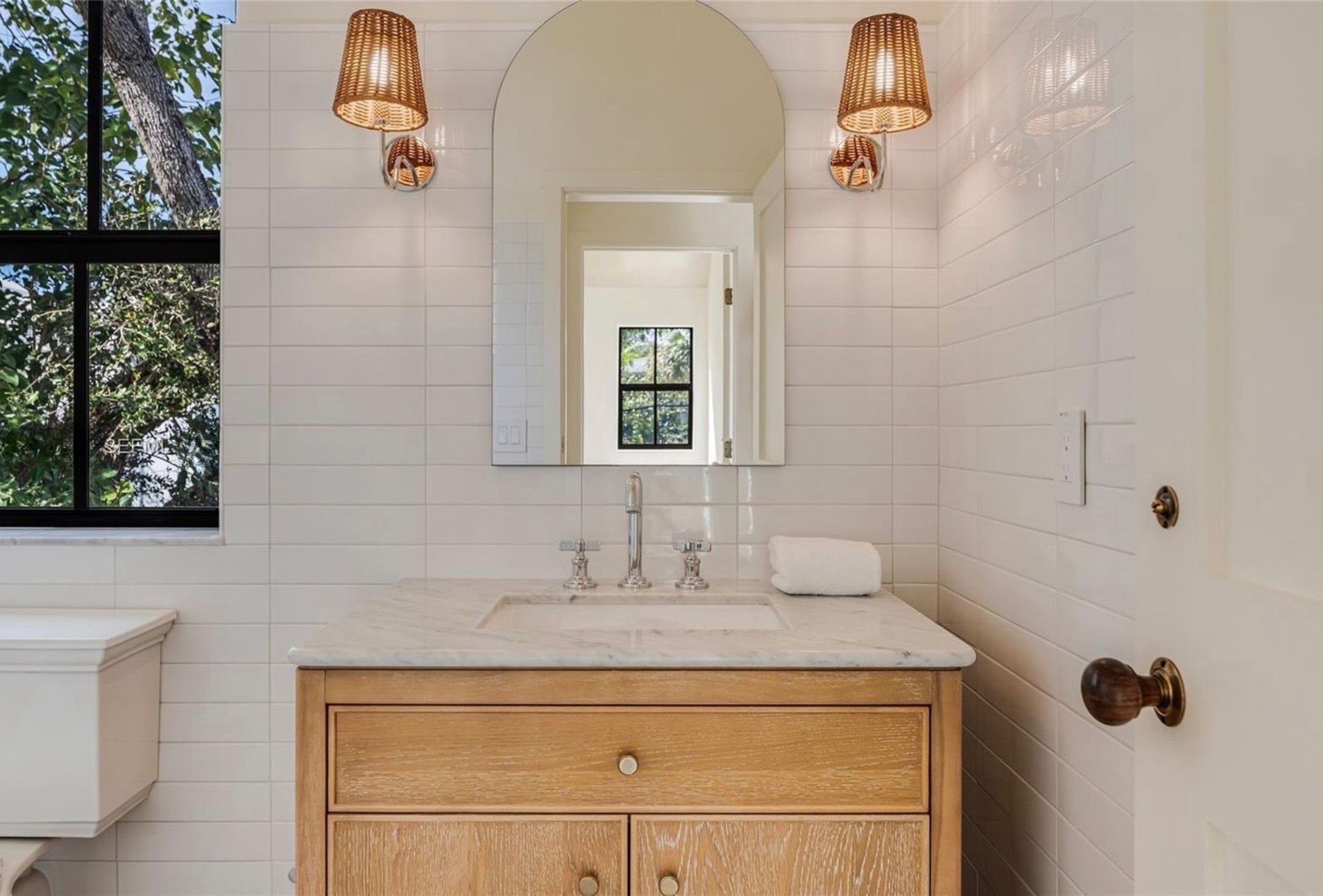 Powder room with arched mirror and oak vanity